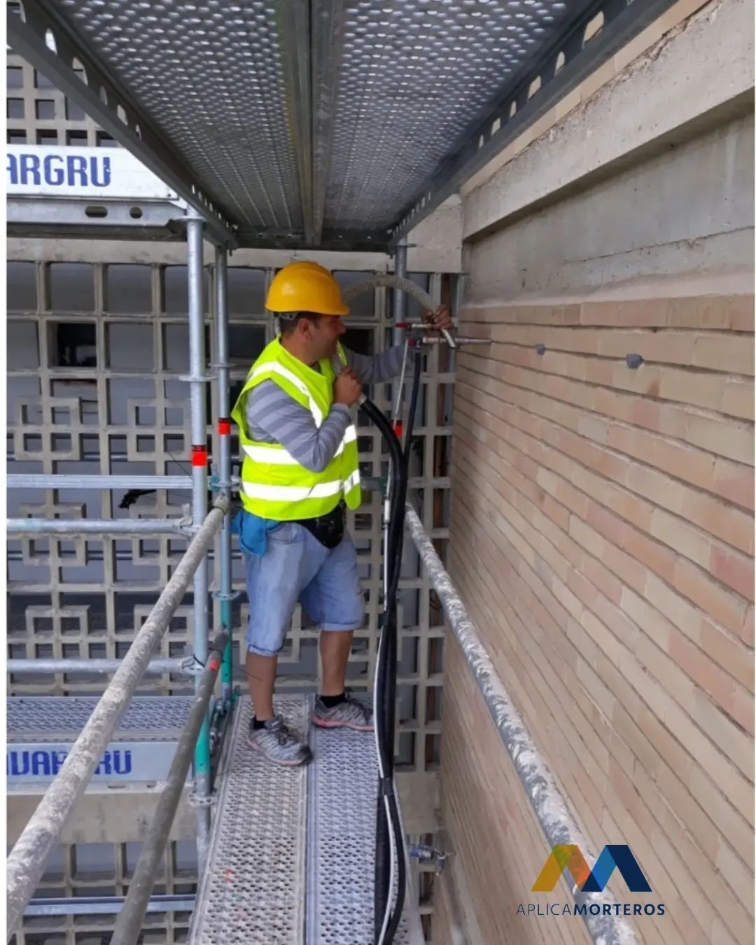 Operario de Aplica Morteros trabajando en una fachada